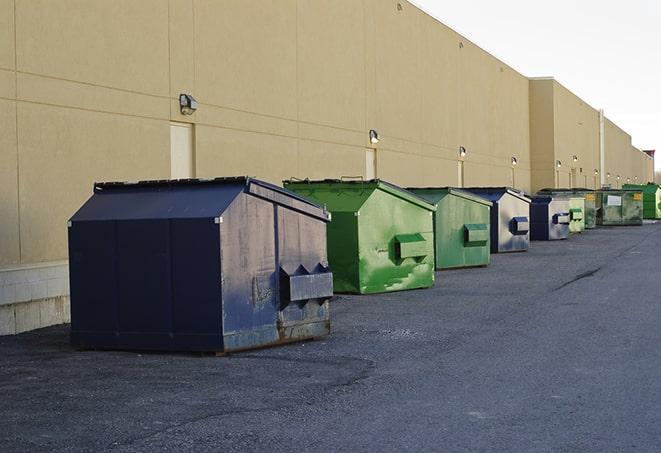 tilted front-load dumpsters being emptied by waste management workers in Bradford